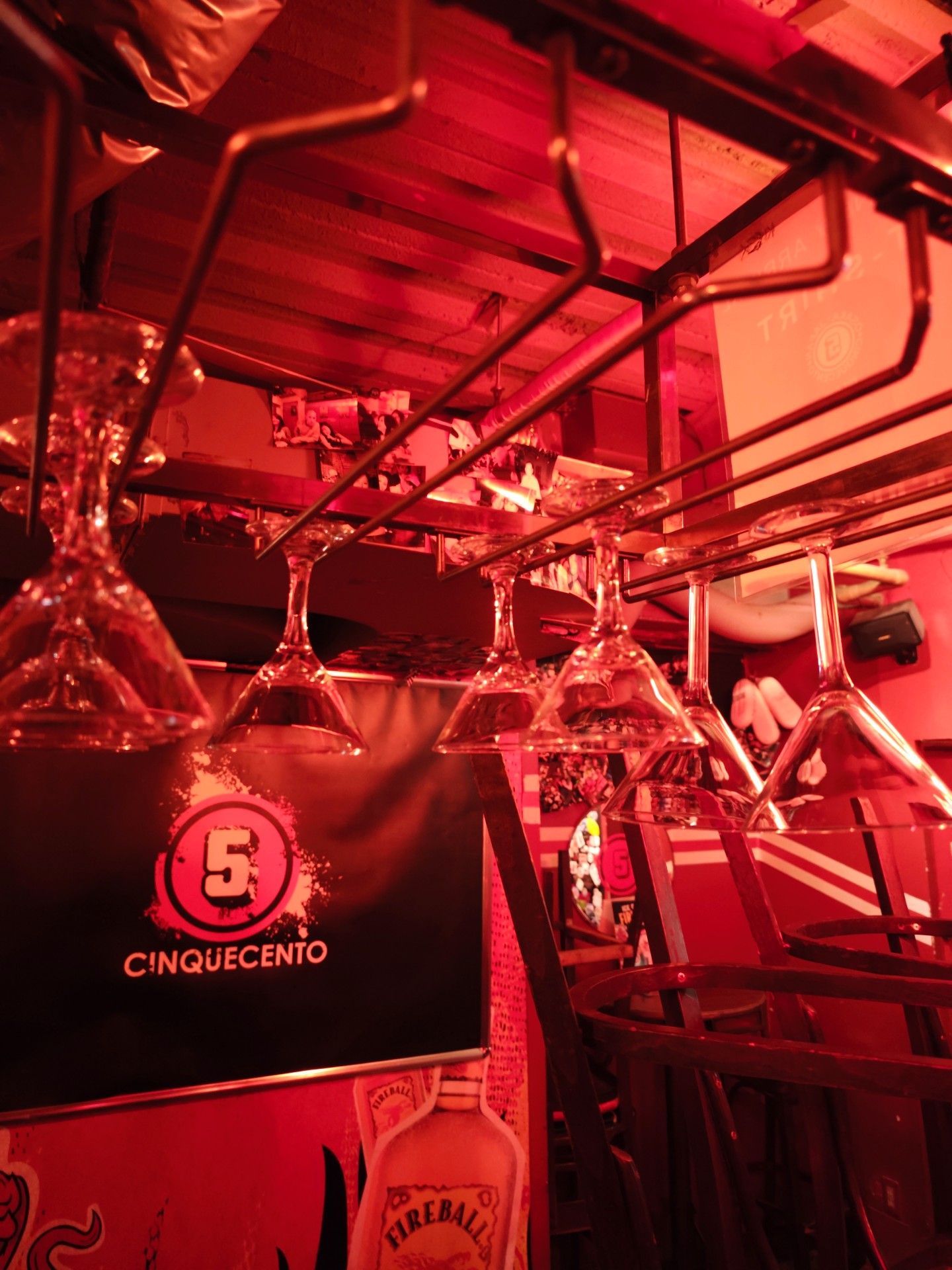 Martini glasses hanging above the bar next to the Cinquecento banner